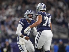 Le quarterback des Dallas Cowboys Dak Prescott (4) réagit avec le plaqueur offensif Terence Steele (78) après avoir lancé une passe de touché contre les Lions de Detroit pendant la seconde moitié d'un match de football de la NFL, le samedi 30 décembre 2023, à Arlington, Texas.