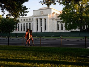 Des piétons passent devant la Réserve fédérale américaine à Washington, DC.