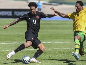 Tajon Buchanan du Canada, à gauche, se bat pour le ballon avec Ethan Pinnock, de la Jamaïque, à droite, lors du match quart de finale de la Ligue des Nations de la Concacaf au stade national de Kingston, en Jamaïque, le samedi 18 novembre 2023.