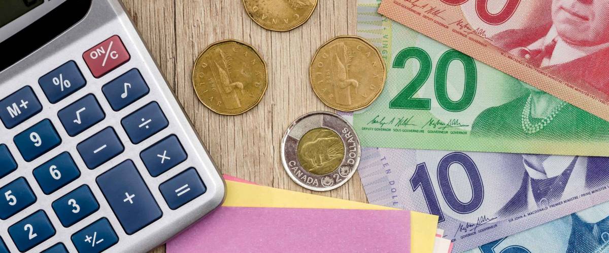 Dollar canadien avec stylo bloc-notes et calculatrice