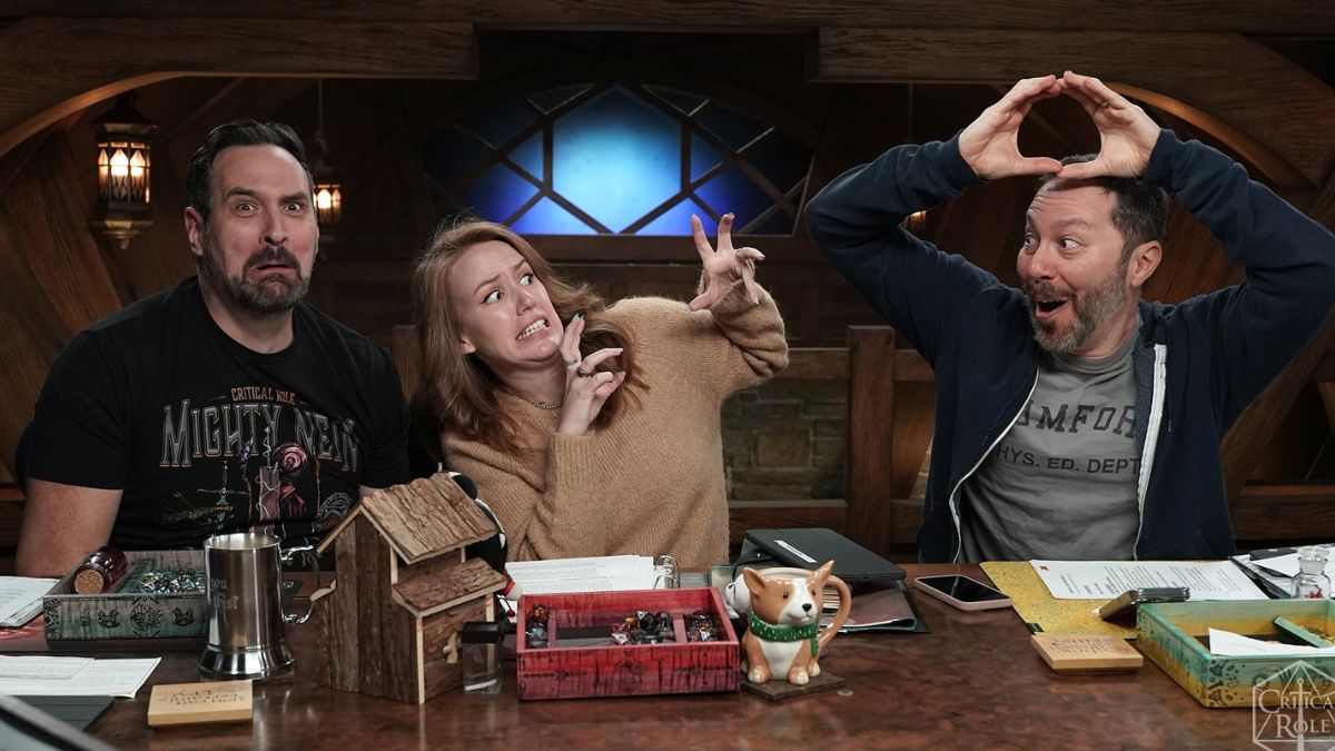 Deux hommes et une femme font des grimaces à une table dans une image promotionnelle de Critical Role : Campagne 3, Épisode 83.