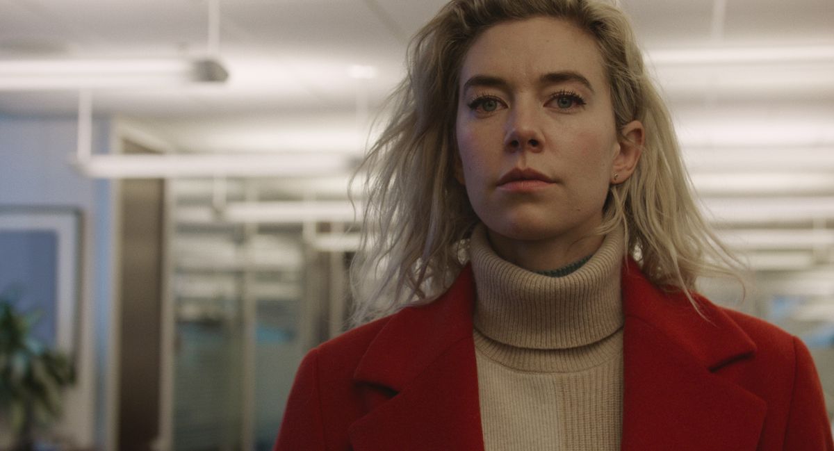 Vanessa Kirby en manteau rouge et cheveux en désordre se promène dans un immeuble de bureaux dans Pieces of a Woman