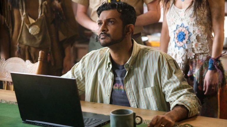 Utkarsh Ambudkar as Jay sitting at a computer looking up in Ghosts.