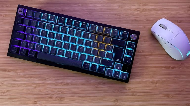 Corsair K65 Plus Wireless with gaming mouse on a wooden desk