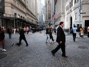 Les gens marchent le long de Wall Street près de la Bourse de New York.