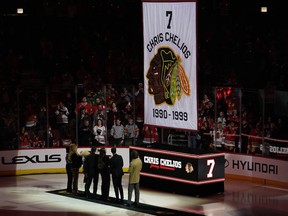 L'ancien joueur des Blackhawks de Chicago Chris Chelios et sa famille regardent son numéro monter jusqu'aux chevrons lors d'une célébration de la retraite du maillot au United Center le 25 février 2024 à Chicago.