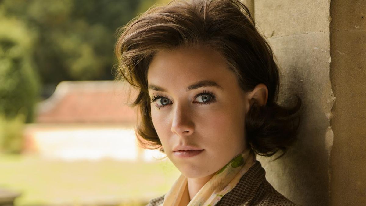 Vanessa Kirby en costume des années 50 dans Queen &  Pays regardant la caméra