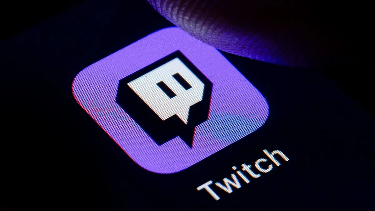 A finger about to press the Twitch button on a screen.