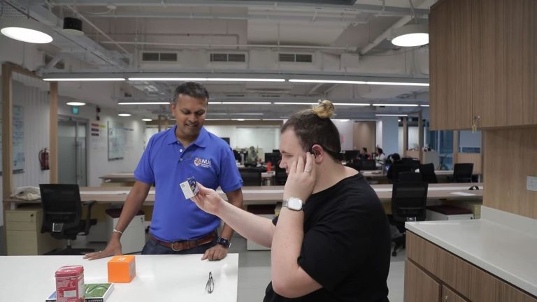 A man with a visual impairment using a wearable device to describe an object he is holding