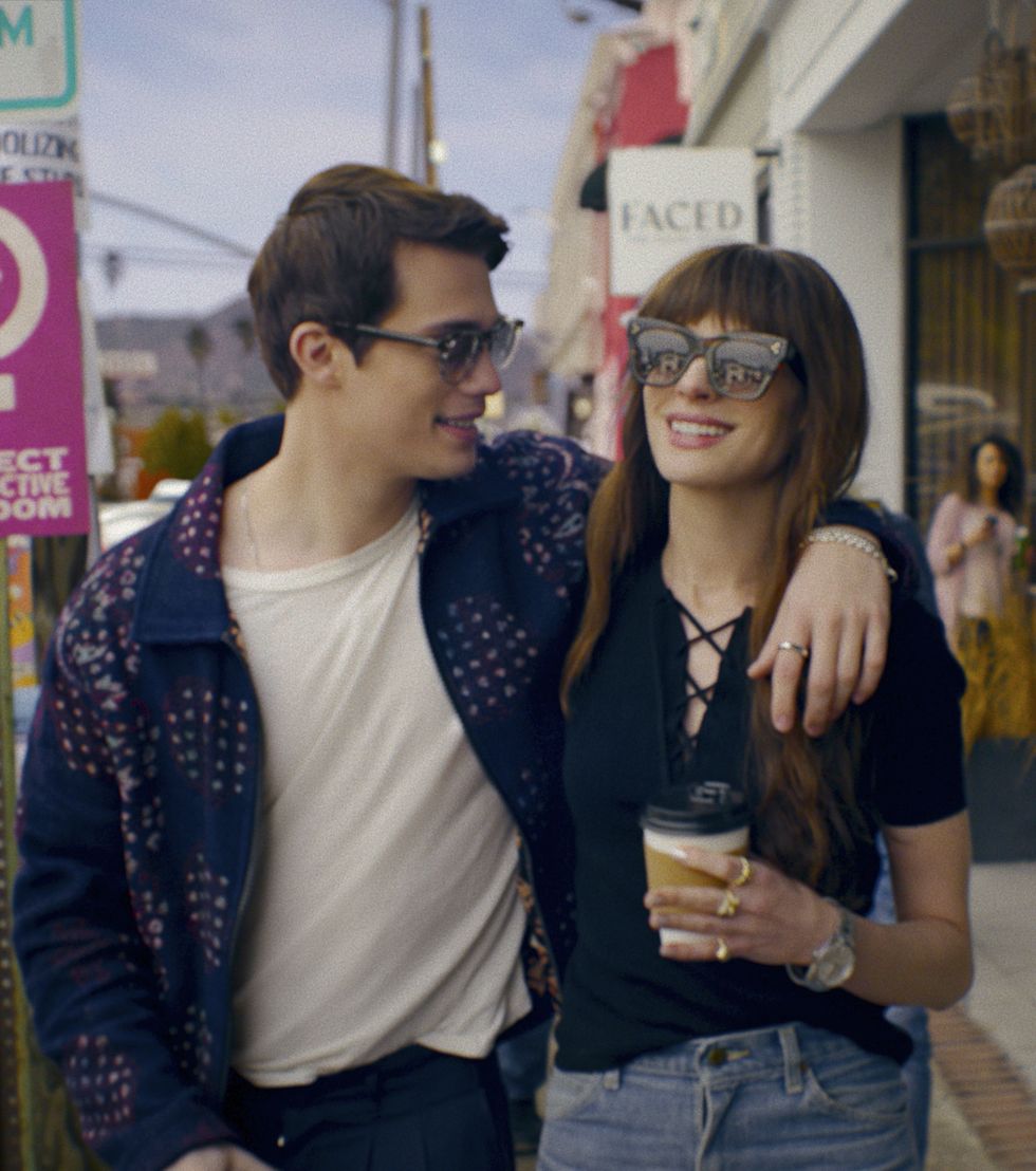 l'idée de toi, Nicholas Galitzine et Anne Hathaway, les bras l'un autour de l'autre et portant des lunettes de soleil