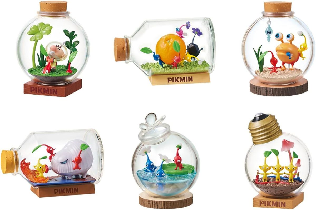 Six images sont présentées, chacune représentant des jouets inclus avec l'ensemble Pikmin Terrarium de Re-Ment.  L'une montre le capitaine Olimar en train de cueillir une créature Pikmin du sol, une où les Pikmin travaillent ensemble pour transporter une orange, deux où les Pikmin combattent des créatures ennemies, une où les Pikmin bleus nagent alors qu'un Pikmin rouge les regarde, et enfin, une où trois Pikmin jaunes se sont donnés la main pour former un circuit fermé qui conduit l'électricité.