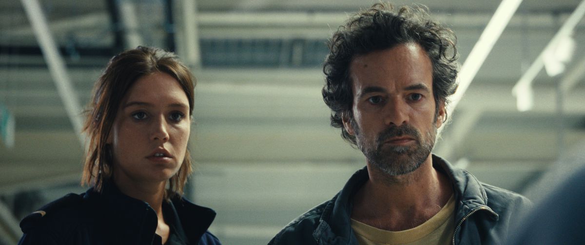 Adèle Exarchopoulos et Romain Duris ont l'air abasourdis alors qu'ils se tiennent dans une épicerie dans Le Règne Animal