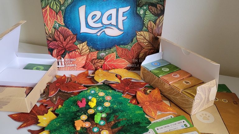 Leaf box and board game components on a white surface