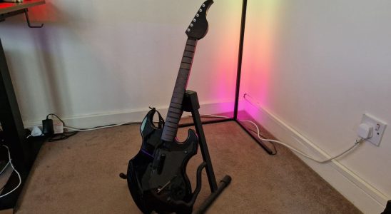 PDP Riffmaster preview image of the guitar on a stand in front of an RGB corner lamp