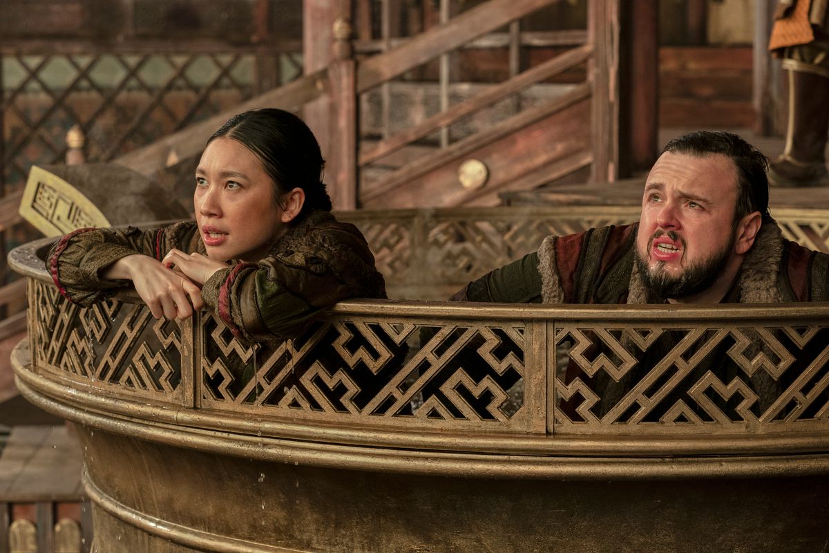 Jin Cheng (Jess Hong) et Jack Rooney (John Bradley) penchés sur le bord d'une marmite bouillante.