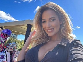 Selfie de Paige Spiranac souriante à côté d’une voiturette de golf.