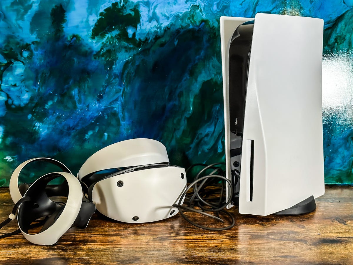 Un casque PSVR 2 à côté de la PlayStation 5 sur une table en bois