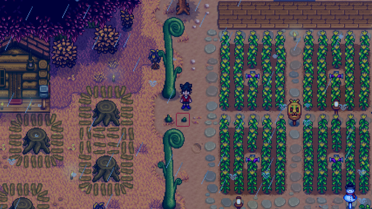 Un agriculteur de Stardew Valley se tient à côté de quelques arbres à tête de violon à l'automne