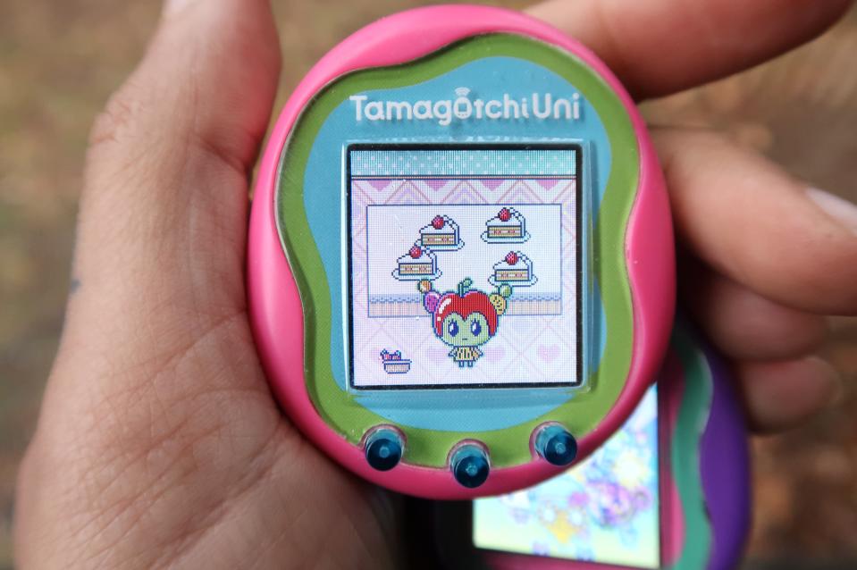 Pink Tamagotchi Uni représenté dans une main affichant le nouveau personnage Tanghulutchi