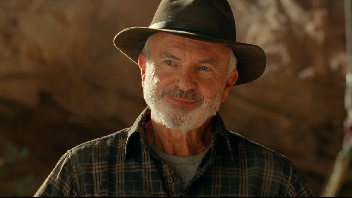 Sam Neill smirking in the middle of a Utah dig site in Jurassic World Dominion.