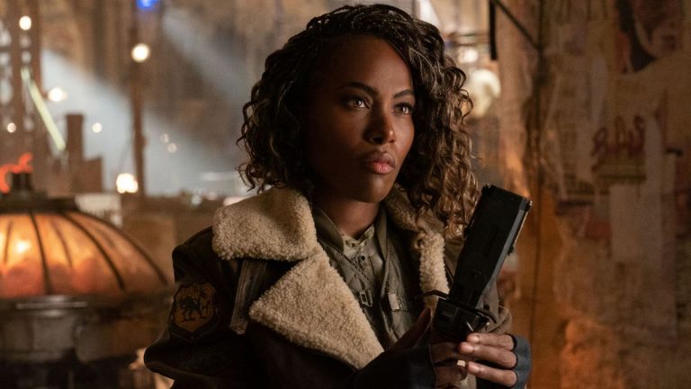 DeWanda Wise raises her taser while standing in the underground market in Jurassic World Dominion.