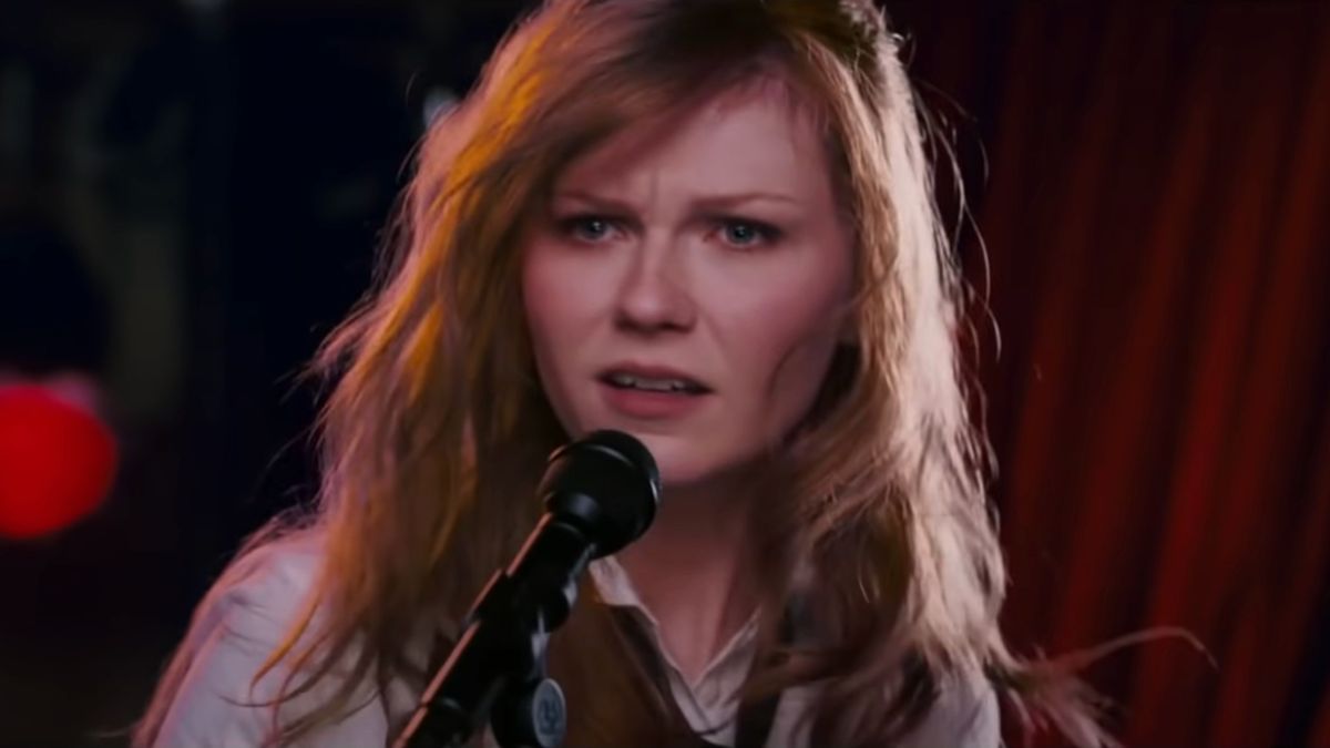 Kirsten Dunst stands perplexed in front of a microphone in Spider-Man 3.