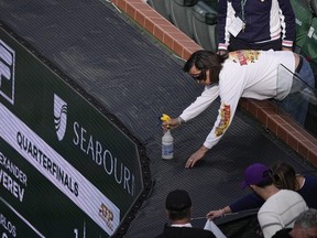 Un apiculteur pulvérise une abeille lors d'une interruption de jeu lors d'un match de quart de finale entre l'Espagnol Carlos Alcaraz et l'Allemand Alexander Zverev au tournoi de tennis BNP Paribas Open, le jeudi 14 mars 2024, à Indian Wells, en Californie.