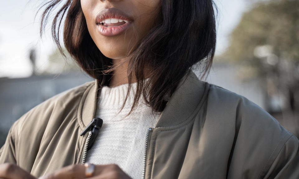 Photo de style de vie d'une personne avec le Shure MoveMic accroché à sa veste légère.