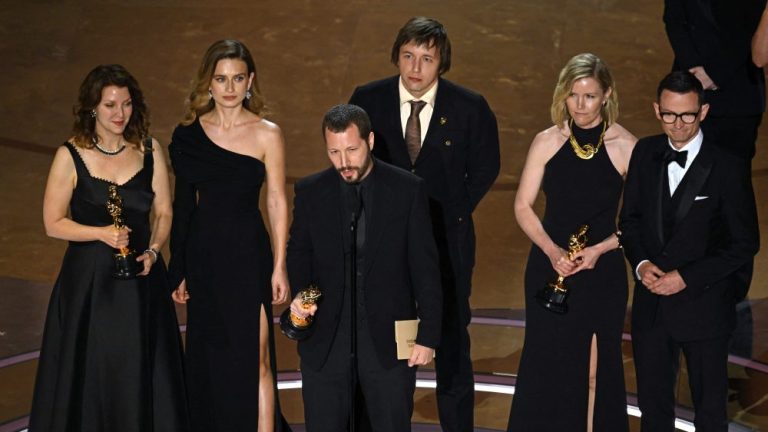 Ukrainian filmmaker Mstyslav Chernov (C), flanked by (from L) Raney Aronson-Rath, Vasilisa Stepanenko, Evgeniy Maloletka, Michelle Mizner and Derl McCrudden, accepts the award for Best Documentary Feature Film for "20 Days in Mariupol" onstage during the 96th Annual Academy Awards at the Dolby Theatre in Hollywood, California on March 10, 2024. (Photo by Patrick T. Fallon / AFP) (Photo by PATRICK T. FALLON/AFP via Getty Images)