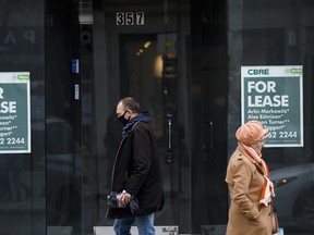 Les piétons passent devant une devanture de magasin avec un panneau « À louer » à Toronto.