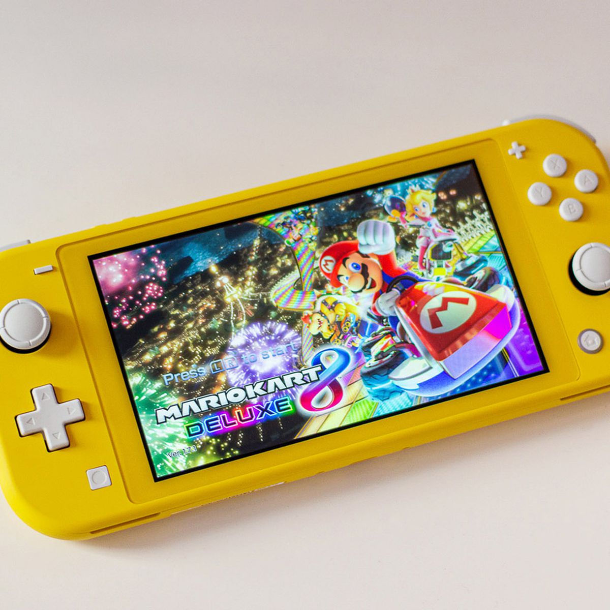 une Nintendo Switch Lite jaune avec l'écran d'accueil de Mario Kart 8 Deluxe dessus