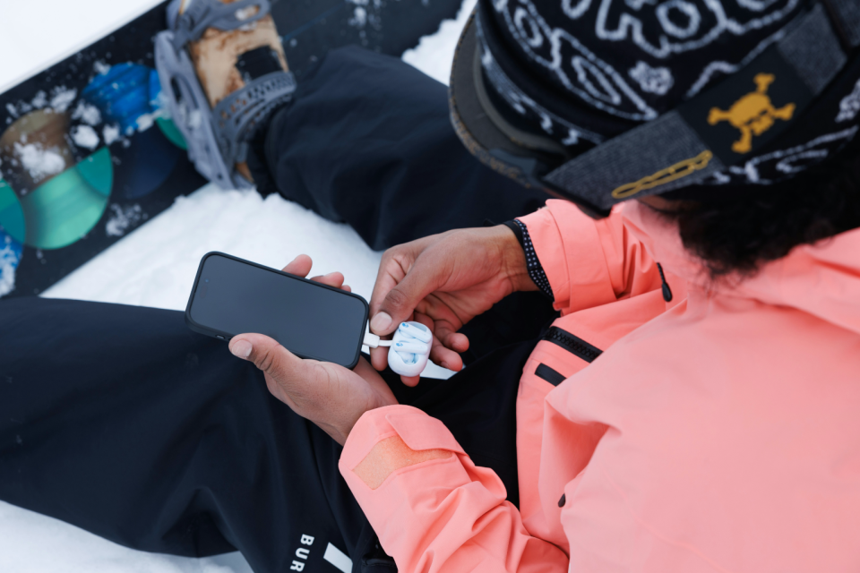 Écouteurs branchés sur un smartphone pour charger.