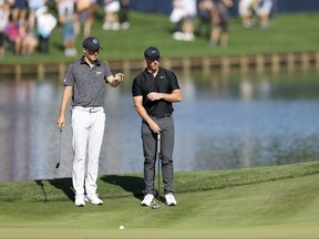 Jordan Spieth, des États-Unis, et Rory McIlroy, d'Irlande du Nord, regardent depuis le 16e green.