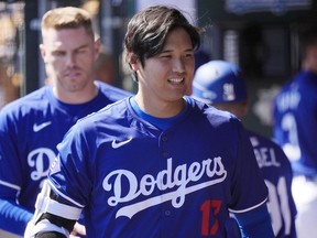 Shohei Ohtani, du Japon, des Dodgers de Los Angeles, traverse l'abri lors du match de baseball d'entraînement de printemps de l'équipe contre les Mariner de Seattle, le 13 mars 2024, à Phoenix.  À partir de son neuvième match d'ouverture international, la Major League Baseball voyagera partout dans le monde en 2024. Ohtani et les Dodgers affrontent Manny Machado et les Padres de San Diego à Séoul, en Corée du Sud.