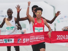 Le coureur de fond chinois He Jie franchit la ligne d'arrivée du semi-marathon de Pékin.