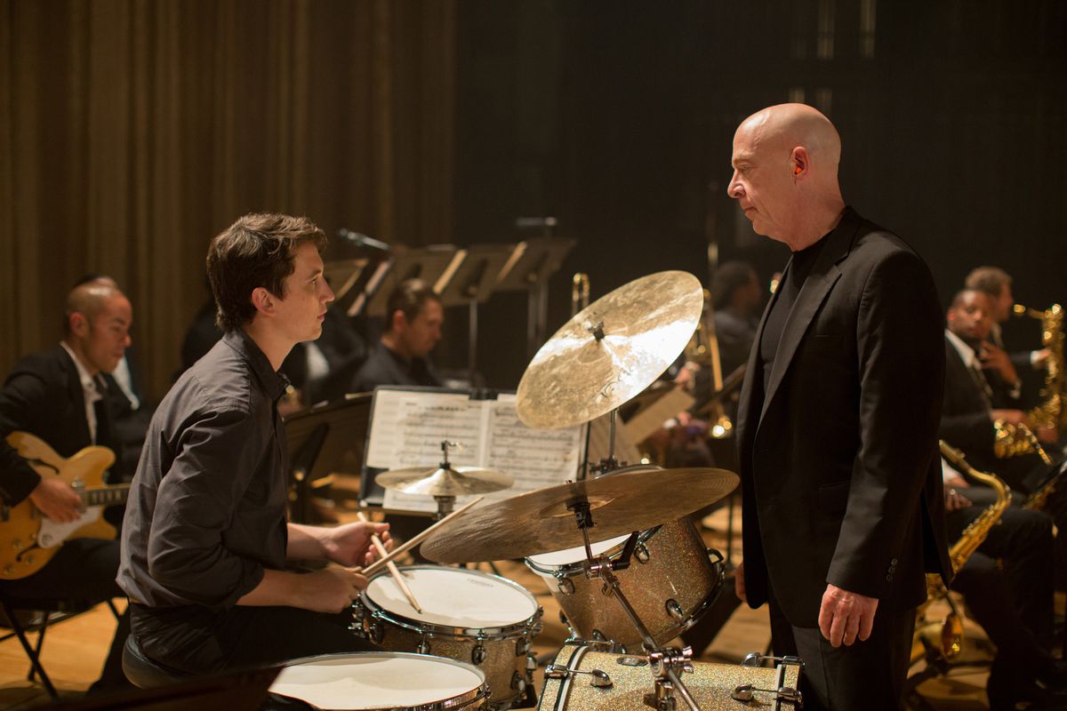 Andrew Neiman (Miles Teller) est assis devant un stand de batterie en face de son chef d'orchestre Fletcher (JK Simmons) dans Whiplash.