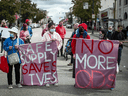 Les gens brandissent des banderoles lors d'une marche à Vancouver à l'occasion de la Journée internationale de sensibilisation aux surdoses pour se souvenir de ceux qui sont morts pendant la crise des surdoses et pour appeler à un approvisionnement sûr en drogues illicites.