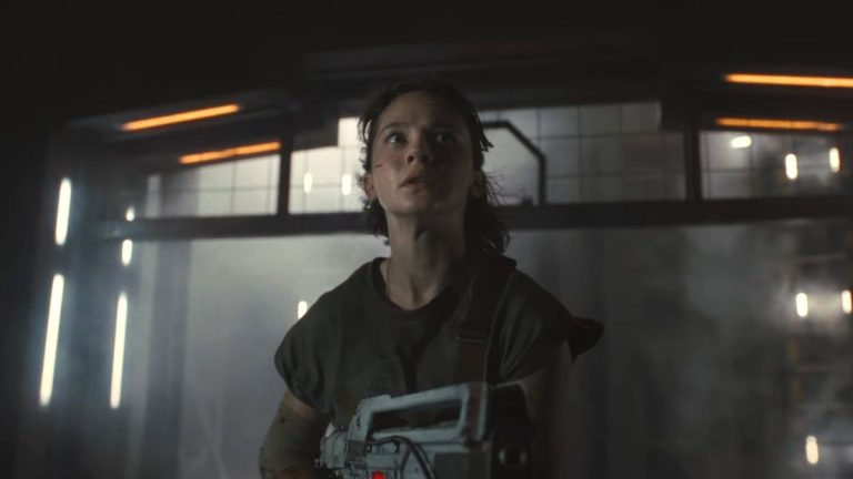 Cailee Spaeny looks terrified while holding a pulse rifle in an empty hallway in Alien: Romulus.