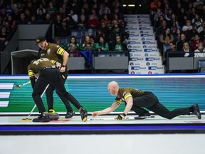 Le capitaine des Manitoba-Carruthers Brad Jacobs, à droite, lance une pierre alors que le deuxième Derek Samagalski, arrière gauche, et le premier Connor Njegovan, avant gauche, balayent alors qu'ils affrontaient l'équipe Manitoba-Dunstone lors des séries éliminatoires au Brier, à Regina, le 8 mars 2024. Jennifer Jones et Brad Jacobs ont rebondi après des défaites déséquilibrées en ouverture du tournoi avec des victoires lors du premier match nul de mercredi au Championnat des joueurs du Grand Chelem de curling.