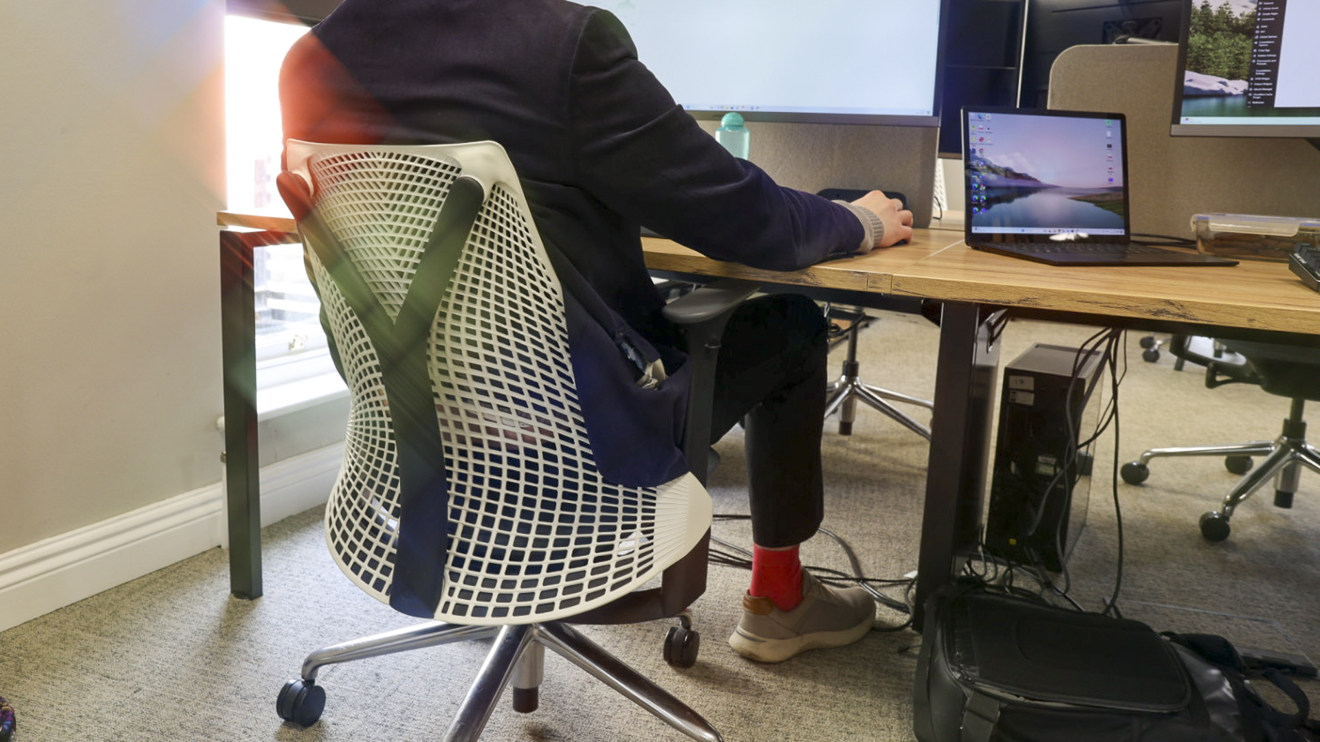 Une personne assise sur la chaise de bureau Herman Miller Sayl