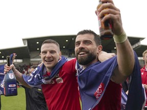 Paul Mullin et Elliot Lee de Wrexham sur le terrain célébrant leur promotion en League One après le coup de sifflet final du match Sky Bet League Two au SToK Cae Ras, Wrexham, le samedi 13 avril 2024.