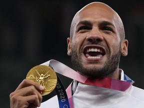 DOSSIER – Lamont Marcell Jacobs, d'Italie, pose avec sa médaille d'or après la finale du 100 mètres hommes aux Jeux olympiques d'été de 2020, le lundi 2 août 2021, à Tokyo.  L'athlétisme est sur le point de devenir le premier sport à introduire des prix en argent aux Jeux olympiques, World Athletics ayant annoncé mercredi 10 avril 2024 qu'elle verserait 50 000 dollars aux médaillés d'or à Paris.