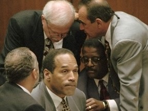 OJ Simpson est entouré de ses avocats de la défense, dans le sens des aiguilles d'une montre en partant de la gauche, Ken Spaulding, dos à la caméra, Gerald Uelmen, Robert Shapiro et Johnnie Cochran Jr., alors qu'ils discutent de leurs plans pour contester l'admissibilité des enregistrements du détective à la retraite de la police de Los Angeles, Mark Fuhrman. lors de son procès, le mardi 29 août 1995 à Los Angeles.