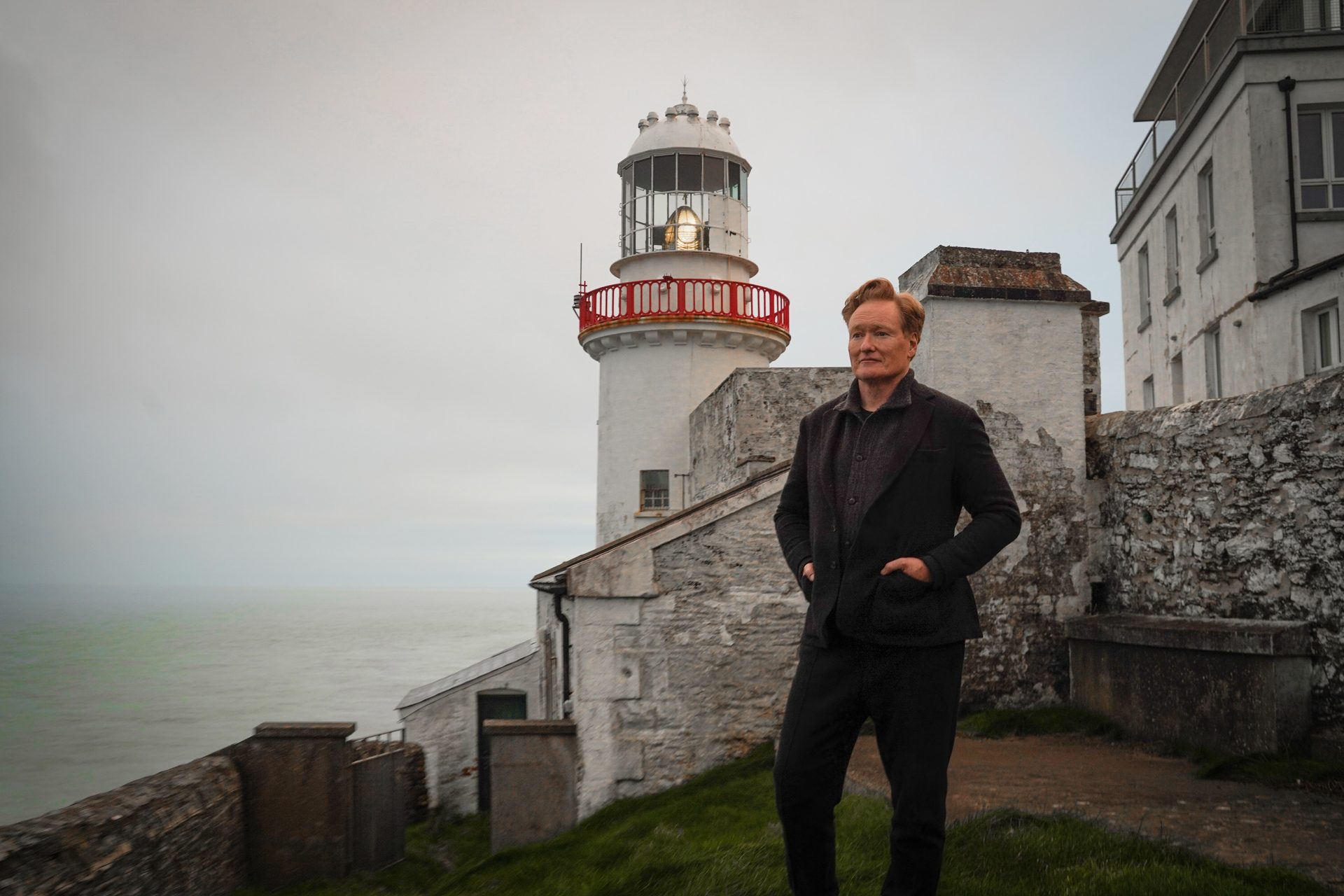 Conan O'Brien stands in front of a lighthouse in Conan O'Brien Must Go