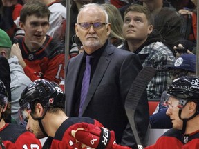 DOSSIER – Lindy Ruff, entraîneur-chef des Devils du New Jersey, au centre, regarde vers la glace pendant la troisième période d'un match de hockey de la LNH contre les Hurricanes de la Caroline à Raleigh, en Caroline du Nord, le 10 février 2024. Ruff revient à Buffalo pour un deuxième passage en tant que entraîneur des Sabres.  Le directeur général Kevyn Adams a annoncé l'embauche le lundi 22 avril 2024.