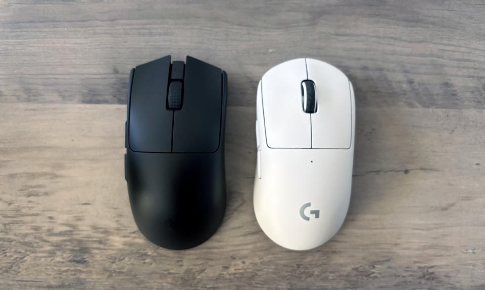 Une souris de jeu Razer Viper V3 Pro noire et une souris de jeu Logitech G Pro X Superlight 2 blanche reposent côte à côte sur une table en bois marron.