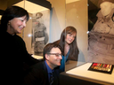 Les trois petits-enfants du lieutenant-colonel Currie (de gauche à droite) : David, Brenda et Sandy Currie, regardent fièrement sa collection de médailles après le dévoilement.  Trois Croix de Victoria ont été dévoilées au Musée canadien de la guerre, le 1er mai 2018.