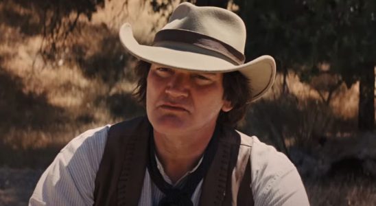 Quentin Tarantino listening intently while dressed in western gear in Django Unchained.