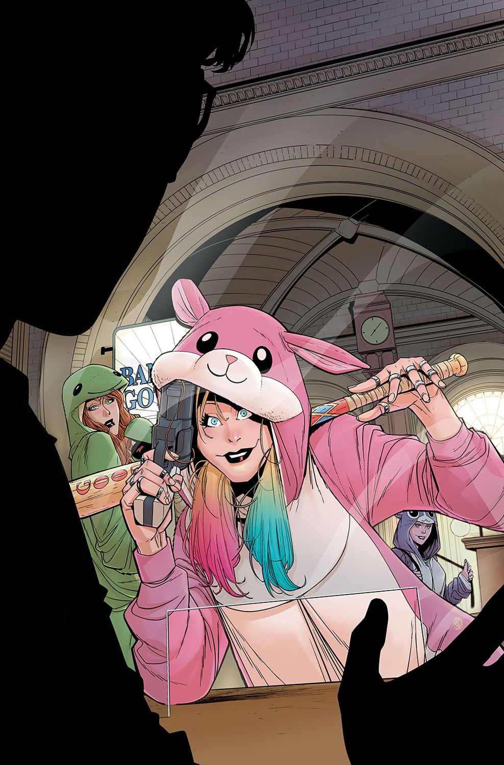 Harley Quinn, vêtue d'une combinaison rose en forme de hamster, se penche, souriante, sur le comptoir d'un caissier de banque, tenant une batte de baseball dans une main et un pistolet dans l'autre.  Derrière elle, Poison Ivy et Catwoman peuvent être vues dans leurs propres combinaisons vertes et violettes.