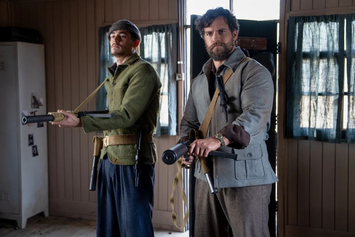 Deux hommes barbus tenant des mitrailleuses datant de la Première Guerre mondiale au ministère de la Guerre sans gentleman.